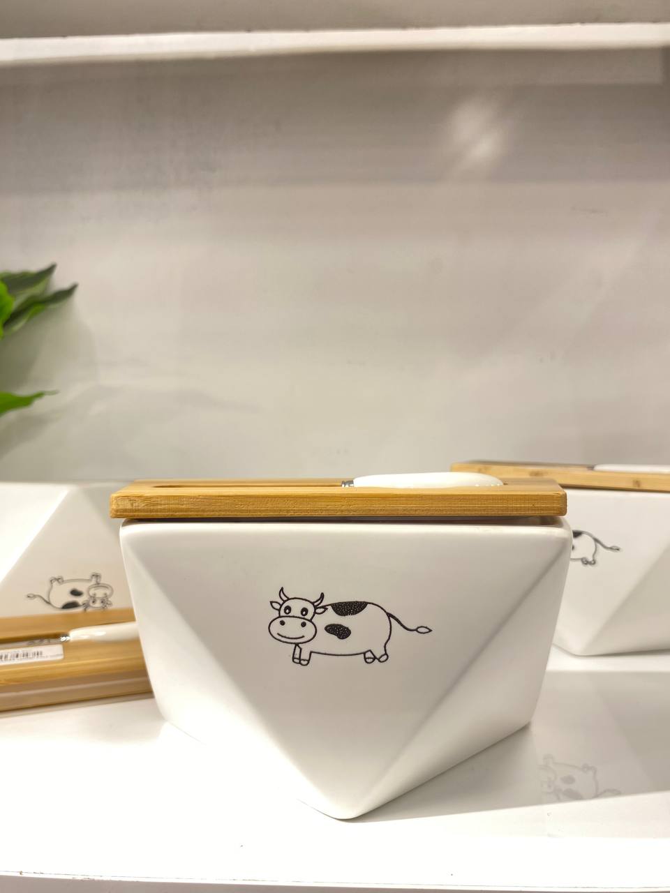 Hexagonal porcelain butter container with an elegant wooden lid and comes with a butter spreader.