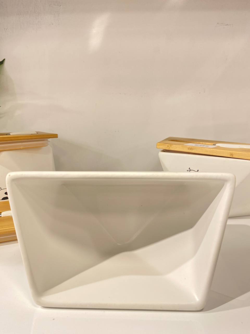 Hexagonal porcelain butter container with an elegant wooden lid and comes with a butter spreader.